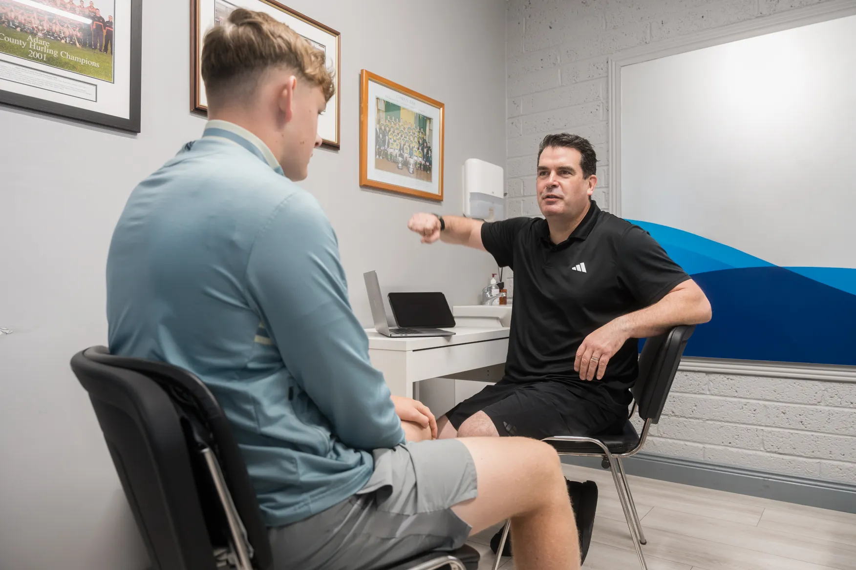 Physiotherapist talking through a treatment plan with a young patient