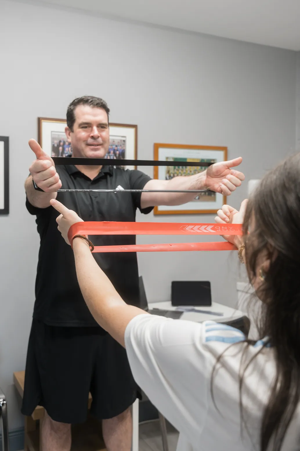 Physiotherapist guiding a patient through a resistance band exercise